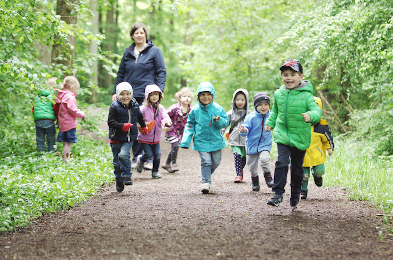 Erzieherin mit Kindern im Wald